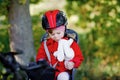 Little toddler girl with security helmet on head sitting in bike seat of her mother or father bicycle. Safe and child Royalty Free Stock Photo