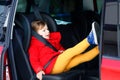 Little toddler girl sitting in car seat and looking out of the window on nature and traffic. Cute kid traveling by car Royalty Free Stock Photo