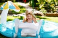 Little toddler girl splashing in an outdoors inflatable swimming pool on hot summer day. Happy healthy child enjoying Royalty Free Stock Photo