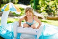 Little toddler girl splashing in an outdoors inflatable swimming pool on hot summer day. Happy healthy child enjoying Royalty Free Stock Photo