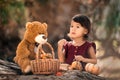 Little toddler girl standing near log with pumpkins and teddy bear in the fall Royalty Free Stock Photo