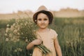 Little toddler girl in a yellow dress walking and picking yellow flowers on a meadow field. Royalty Free Stock Photo