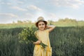 Little toddler girl in a yellow dress walking and picking yellow flowers on a meadow field Royalty Free Stock Photo
