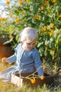 Little Toddler Girls Sitting in the Summer Garden Picking Flower