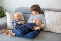 Little toddler and his older brother, having fun at home, tickling and giggle