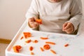Little toddler plays play dough. Modeling orange sun. Creativity imagination