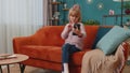 Little toddler school kid girl taking selfie photo with smartphone while sitting on sofa at home Royalty Free Stock Photo