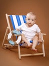 Little toddler sitting on the sunbed Royalty Free Stock Photo