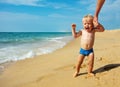 Little toddler walk afraid near sea waves on beach