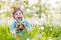 Little toddler wearing Easter bunny ears and eating chocolate at Royalty Free Stock Photo