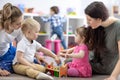 Little toddlers boy and girl with moms playing together in nursery room. Preschool children in day care centre Royalty Free Stock Photo