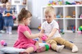 Little toddlers boy and a girl playing together in nursery room. Preschool children in day care centre