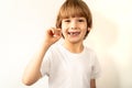 Little toothless boy holds a fallen milk tooth in his hand and smiles Royalty Free Stock Photo