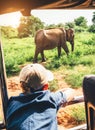 Little tourist boy looking at elephant calf and enjoying his jeep safari activities at  National Nature Park Udawalawe in Sri Royalty Free Stock Photo