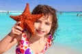 Little tourist girl holding starfish beach Royalty Free Stock Photo