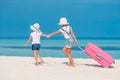 Little tourists girls with big suitcase on tropical white beach Royalty Free Stock Photo