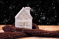 Little toy Christmas house wrapped in warm scarf Royalty Free Stock Photo