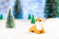 little toy deer sitting in the snow in the forest, greeting card, copy space Royalty Free Stock Photo