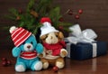 Small toy doggies and teddy bear, gift boxes, nuts and Christmas fir branches on an old wooden background