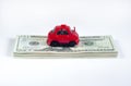 Little toy red car and a stack of money banknotes american dollars on a white isolated background. vehicle loan. Royalty Free Stock Photo