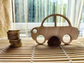 Little toy wooden car and euro money. Concept of the expensiveness of buying a new car, affordability of buying an old