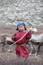 Little tsaatan boy posing with his family`s reindeer.