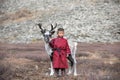 Little tsaatan boy posing with his family`s reindeer.