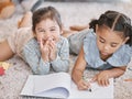 Little two girls drawing with colouring pencils lying on living room floor with their parents relaxing on couch. Little Royalty Free Stock Photo