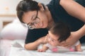 Little two month asian baby lying on stomach and try raised her neck, Asian mother come to help her daughter, Family concept