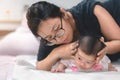 Little two month asian baby lying on stomach and try raised her neck, Asian mother come to help her daughter, Family concept