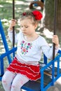 Little ukrainian child girl having fun on a swing