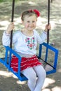 Little ukrainian child girl having fun on a swing