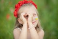 little ukrainian girl looking through heart gesture made with hands in summer green park. Gesture of love to Ukraine by pretty Royalty Free Stock Photo