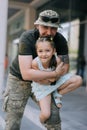 Little Ukrainian girl meets her father from the war during his vacation and cheerful plays with him Royalty Free Stock Photo