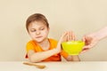 Little unhappy boy refuses to eat porridge Royalty Free Stock Photo