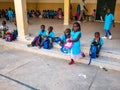 Little unidentified cute kids children are sitting on a bench in their primary school