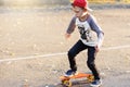 Little urban boy with a penny skateboard. Young kid riding in th Royalty Free Stock Photo