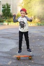 Little urban boy with a penny skateboard. Young kid riding in th Royalty Free Stock Photo