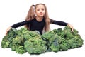 Little vegan girl sits and hugs huge pile of broccoli. healthy organic food concept Royalty Free Stock Photo