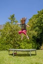 Little very happy cute child girl enjoys jumping on trampoline Royalty Free Stock Photo