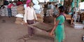 Little village girl clearing dust from wheat seeds at wholesale market Royalty Free Stock Photo