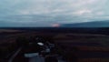 Small village and the muddy road with the horrific explosions on the background, aerial shot