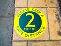 Little Waitrose, London Bridge supermarket. Outside floor pavement sticker,`Please keep a safe distance 2 metre`
