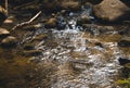 Little Waterfall Between Boulders and Rocks on a Stream