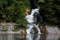 little waterfall from a forest into a mountain lake detail view Royalty Free Stock Photo