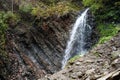 Little waterfall and geological mountain folds in the mountains