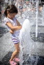 Funny little girl in the fountain plays with splashes of water Royalty Free Stock Photo