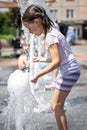 Funny little girl in the fountain plays with splashes of water Royalty Free Stock Photo