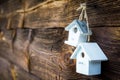 Little white birdhouses hanging on old wooden wall