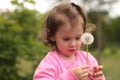 Little white child holds a dandelion in his hands while standing outdoors Royalty Free Stock Photo